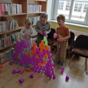 Troje dzieci buduje wieże z kubeczków