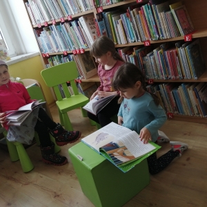 Troje dzieci ogląda książki