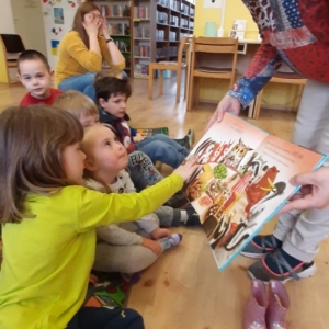 Agnieszka Okarmus z Oddziału Dziecięcego Miejskiej Biblioteki Publicznej w Świebodzicach pokazuje dzieciom ilustracje z czytanego opowiadania