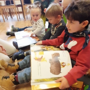 Dzieci oglądją książki "Wiewiórki, które nie chciały się dzielić" oraz "Mysz, która chciała być lwem"