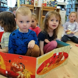 Dzieci w dwustronnej, rokładanej książce "Król lew"