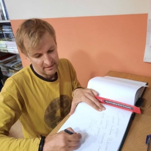 Michał Szulim dokonuje wpisu do kroniki bibliotecznej