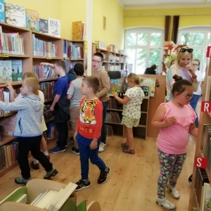 Dzieci przeglądają książki na półkach